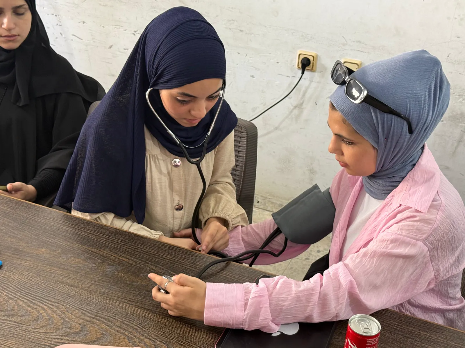 Two students practising blood pressure measurement with a stethoscope