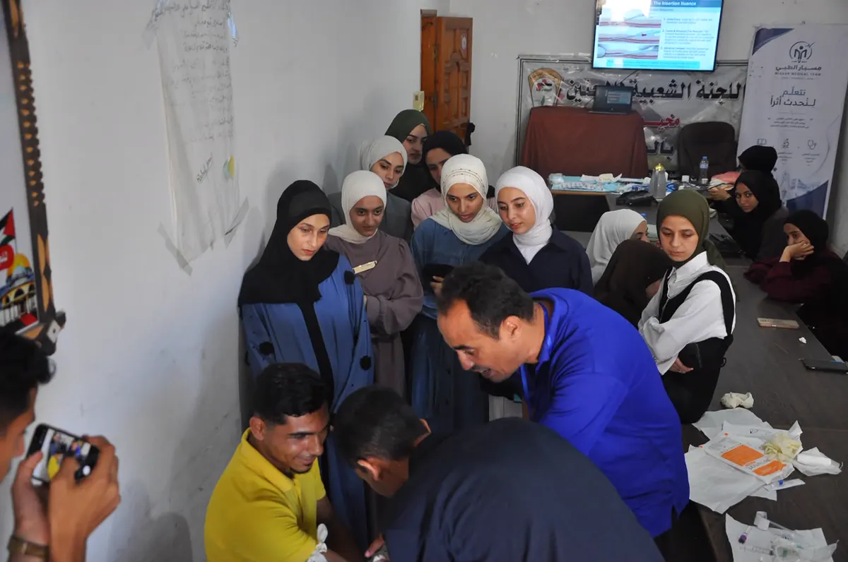 Students watching a trainer demonstrate a skill at the front of the room