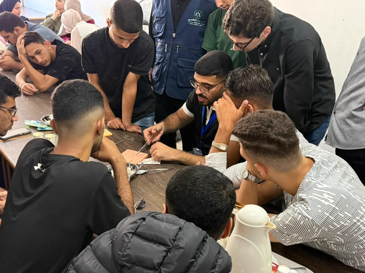 Students practising suturing around a table