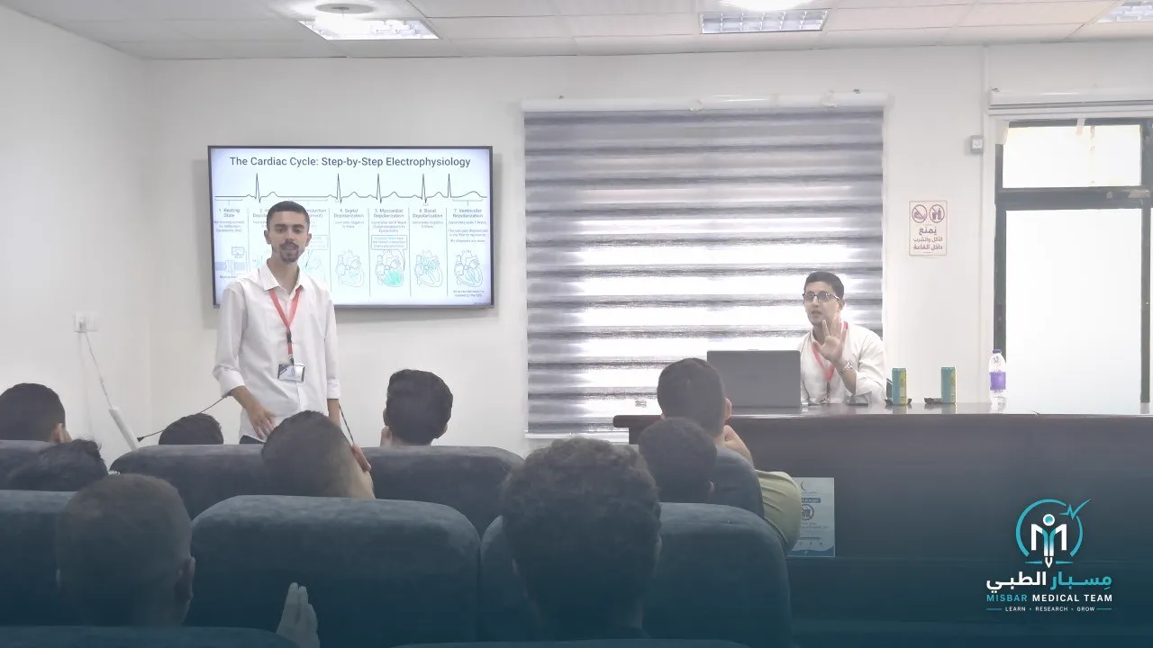 A trainer explains the cardiac cycle on a screen to a seated audience of students