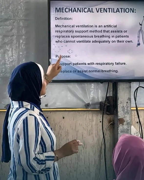 A trainer points at a slide defining mechanical ventilation